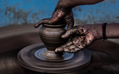 hands forming pottery using a pottery wheel